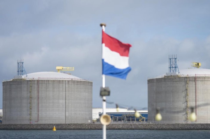 La bandera nacional holandesa ondea desde un barco turístico mientras los silos de gas natural licuado (GNL) se levantan en la costa en el puerto de Róterdam, Países Bajos. Foto: Forbes La bandera nacional holandesa ondea desde un barco turístico mientras los silos de gas natural licuado (GNL) se levantan en la costa en el puerto de Róterdam, Países Bajos. Foto: Forbes